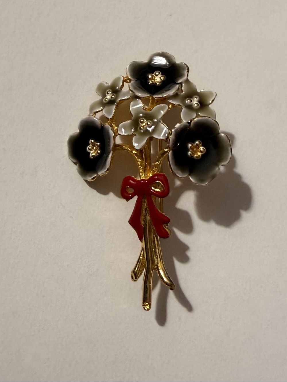 Gold-Tone Floral Bouquet Brooch with Black and White Enamel and Red Bow